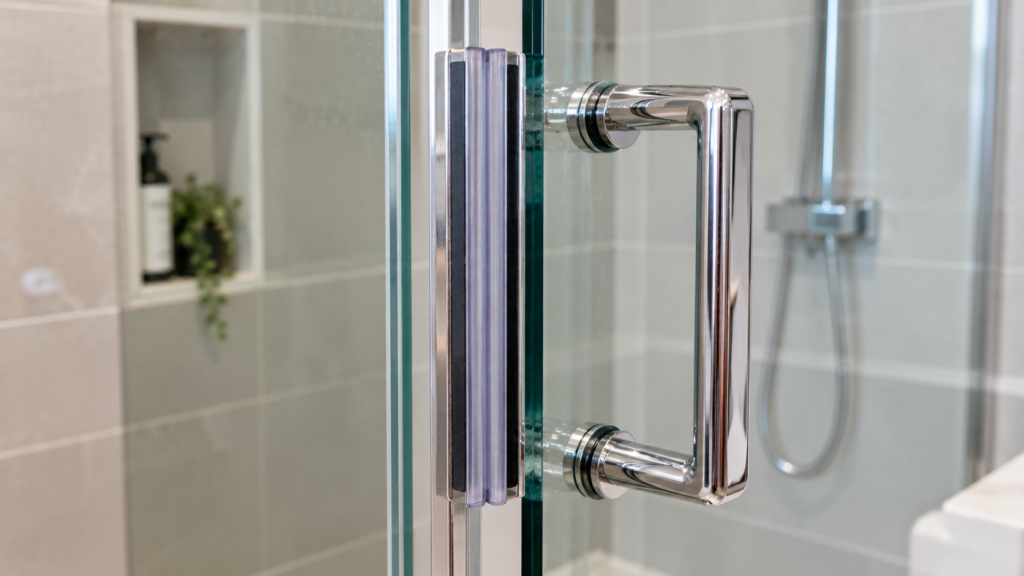 Magnetic catch and handle on a shower screen door